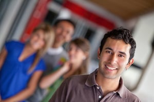 Man at a shopping center with people behind and smiling